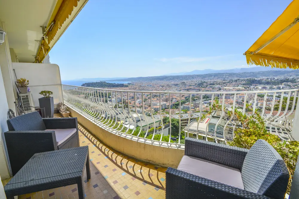 Photo d'un balcon aménagé au soleil en hauteur avec vue sur tout Nice.