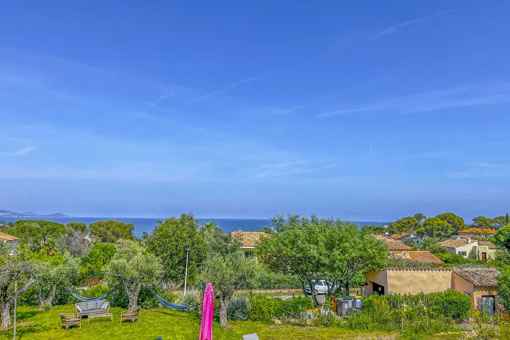 Vue sur le jardin d'une maison entouré de petites maisons voisines.