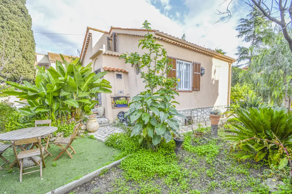 Photos d'une maison en centre ville entourée d'un beau jardin fleuris.